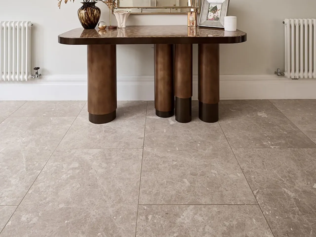 Stone-look floor tiling beneath a hallway table by LN Ceramics